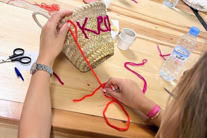 Close-up of a hand embroidering the word