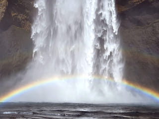 Rainbow in the spraying from the waterfall.