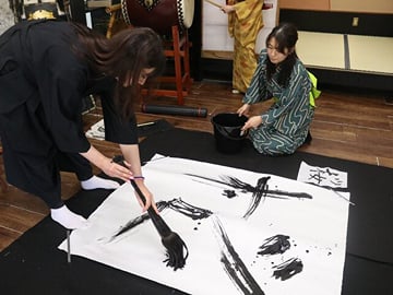 ― Highlight 02 ― Activities,7 ➤With an oversized brush, more than five times larger than usual, the artist puts his soul into creating a powerful, fragile, and beautiful single character on a 150cm x