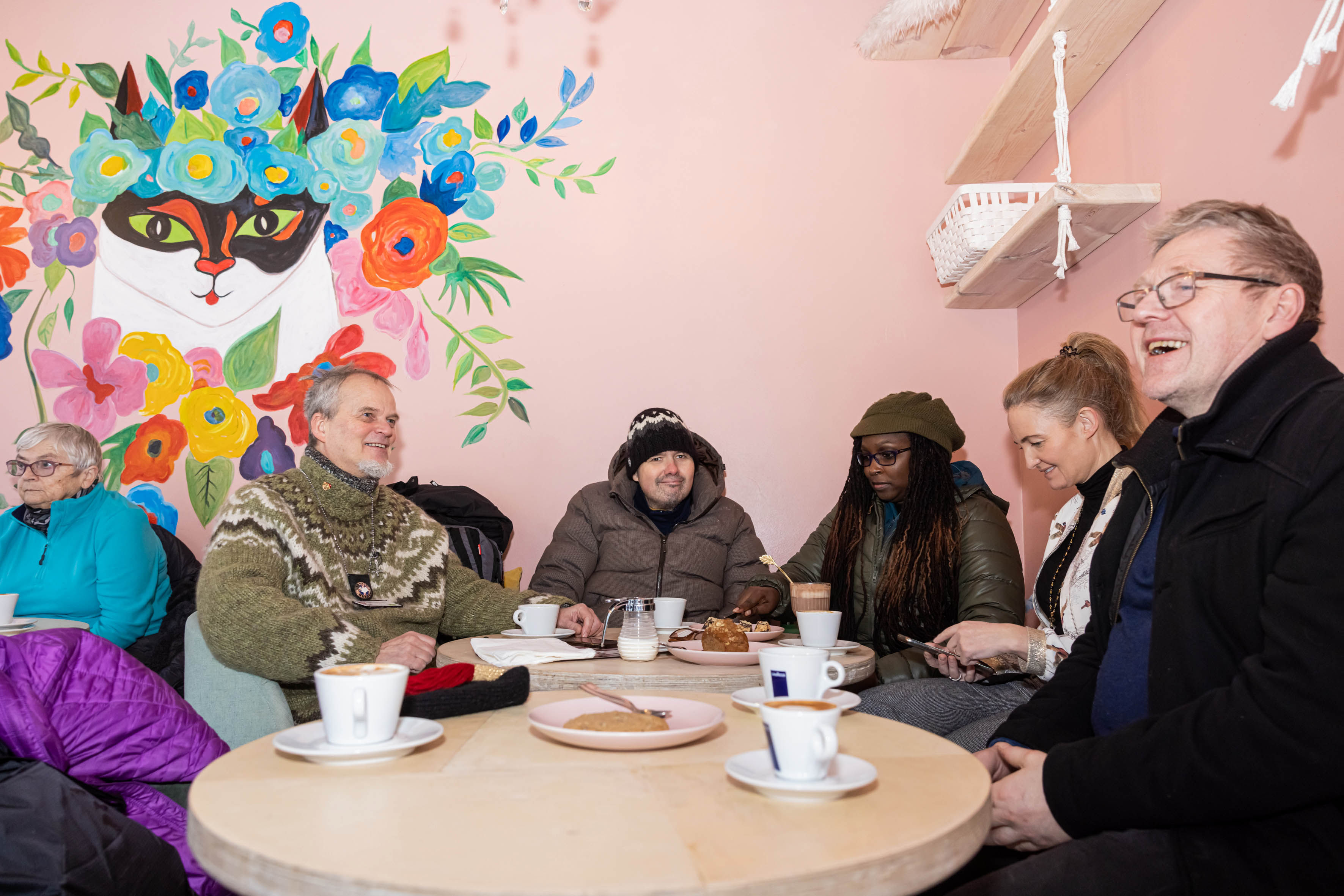 Travellers sitting at a round table enjoying coffee together