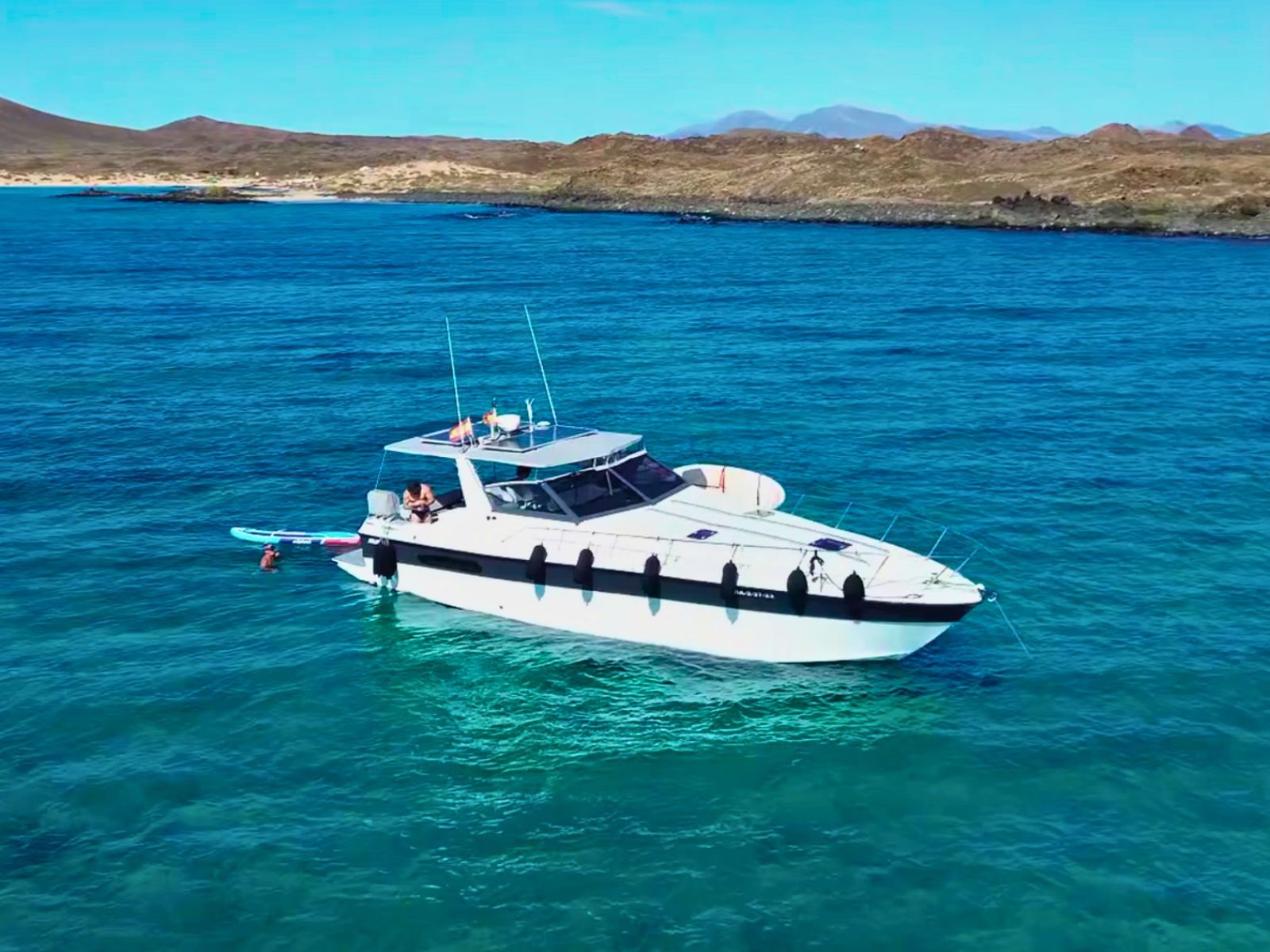 Vista aérea del ARUAL fondeado frente a la Playa de La Concha de Lobos, en aguas turquesas.